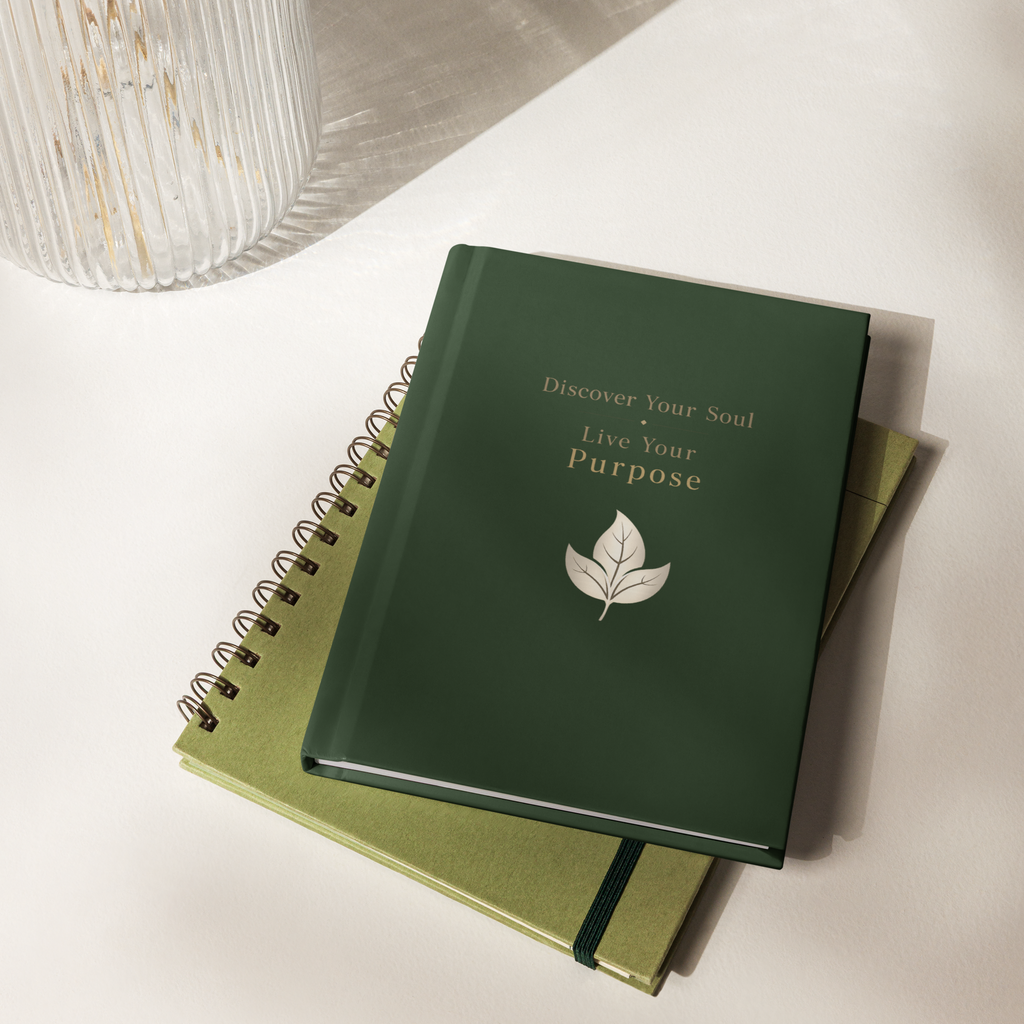 Green notebook with motivational quote and leaf design on a light surface