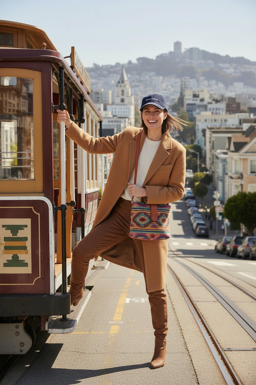 Navy blue baseball cap on woman in San Francisco holding onto trolly